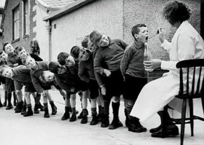 Children line up for a dose of medicine art print by Anonymous